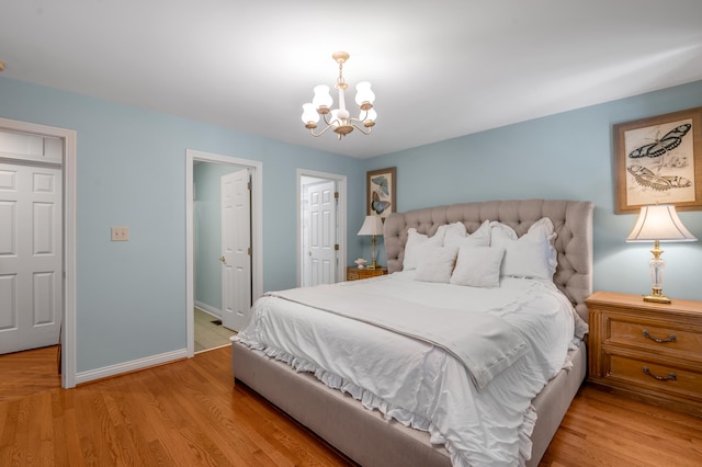 bedroom with light hardwood / wood-style floors and a chandelier