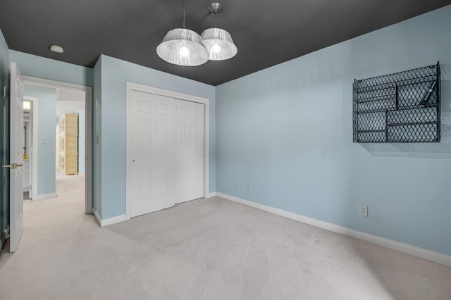 unfurnished bedroom with light carpet and a closet