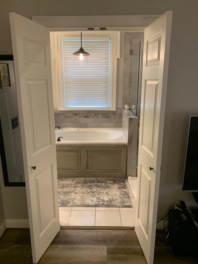 bathroom with wood-type flooring and a tub