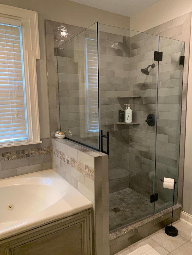 bathroom featuring toilet, tile patterned flooring, and walk in shower