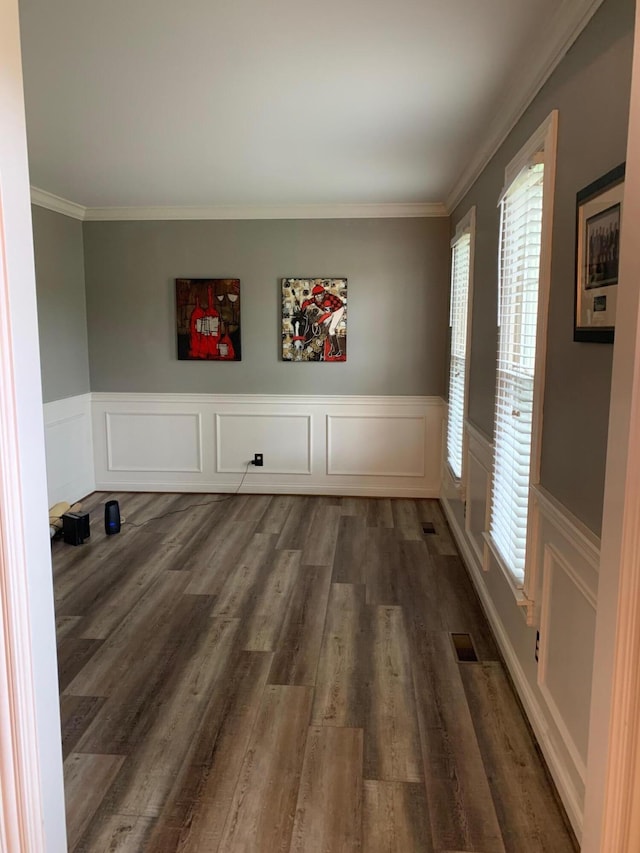 unfurnished room with plenty of natural light, ornamental molding, and dark wood-type flooring