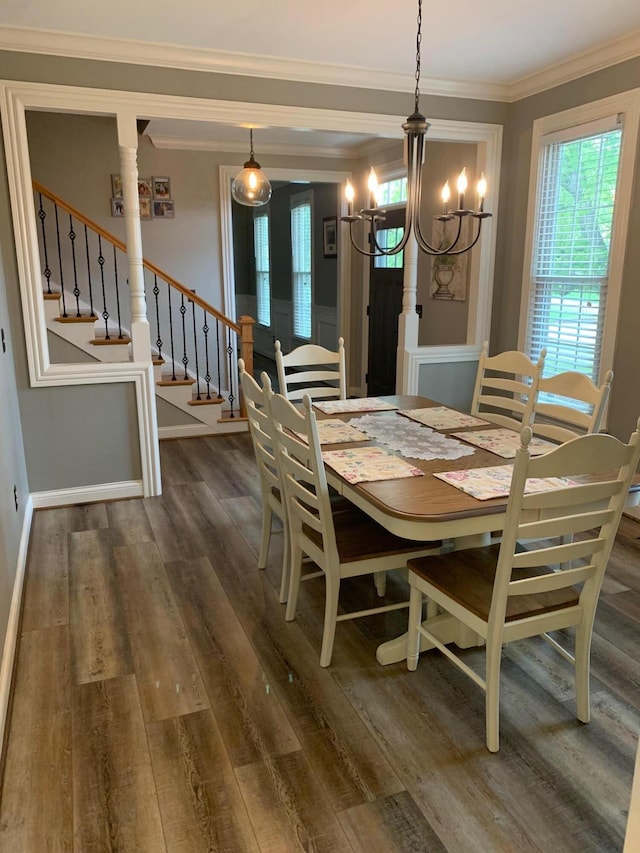 dining space featuring dark hardwood / wood-style flooring, ornamental molding, and a chandelier