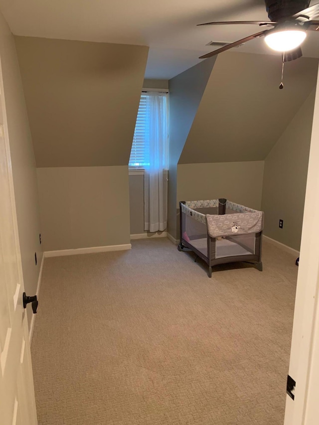 unfurnished bedroom featuring ceiling fan, light colored carpet, and vaulted ceiling