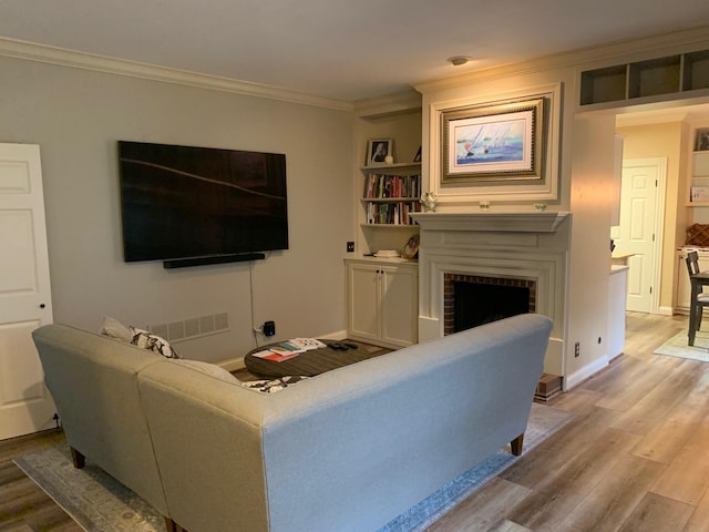 living room featuring a fireplace, hardwood / wood-style flooring, and ornamental molding