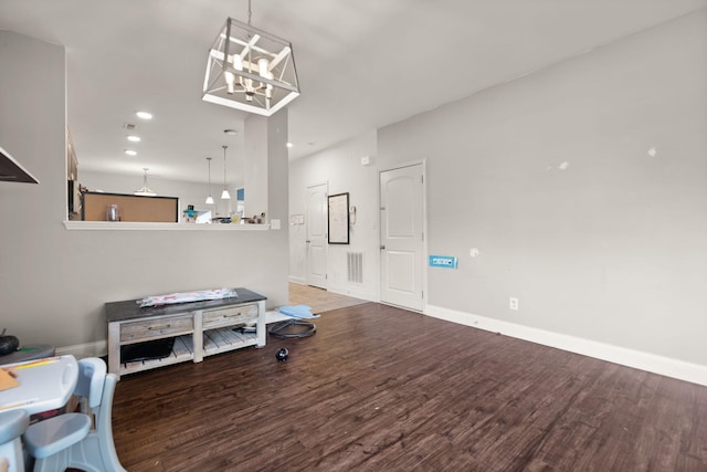 living room with dark wood-type flooring and a chandelier