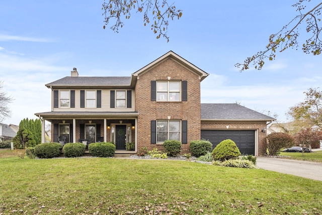 view of front of house with covered porch, a garage, and a front yard