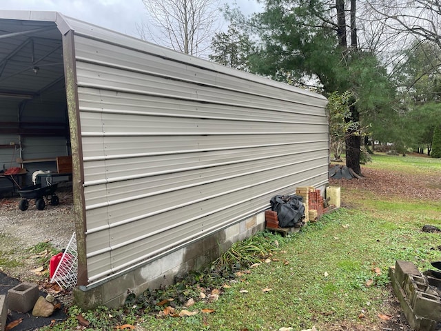 exterior space featuring a lawn, a garage, and an outbuilding