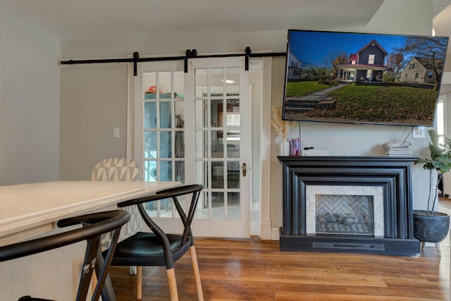 dining area featuring a barn door and wood-type flooring