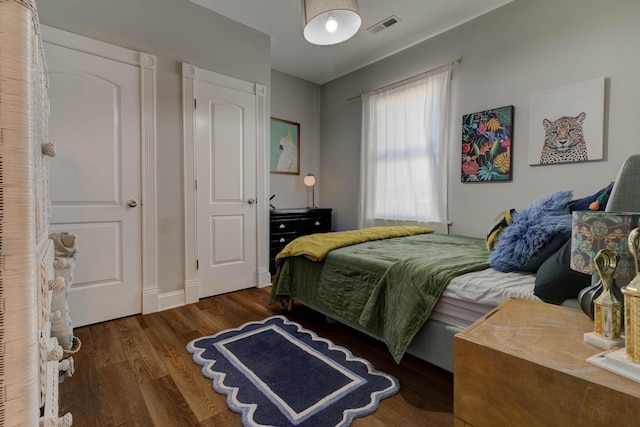 bedroom with dark hardwood / wood-style floors