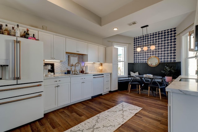 kitchen featuring pendant lighting, white appliances, dark wood-type flooring, sink, and white cabinetry