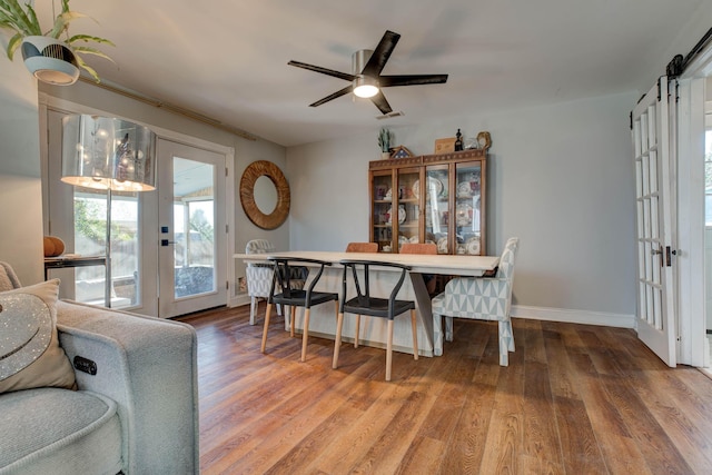 dining space with french doors, ceiling fan, and wood-type flooring