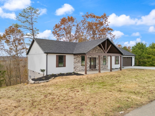 view of front of house with a front lawn, covered porch, and a garage