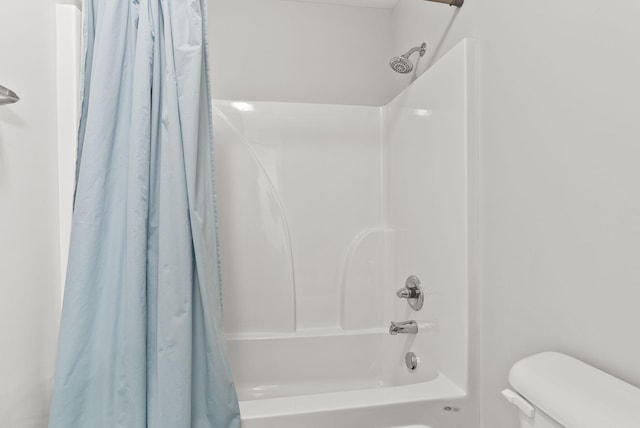 bathroom with shower / bath combination with curtain and toilet