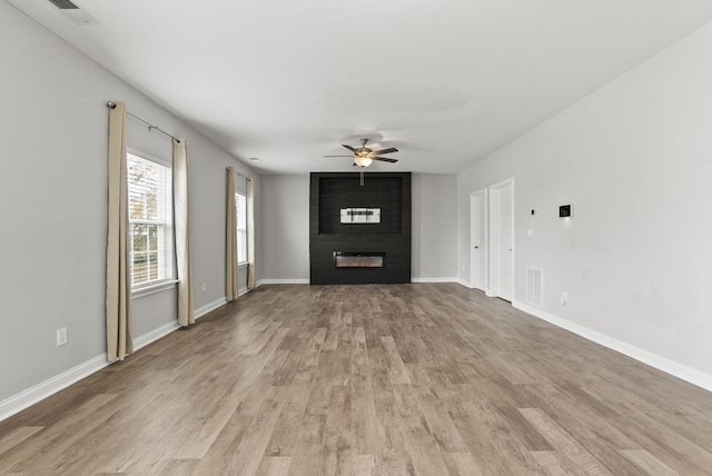 unfurnished living room featuring a fireplace, ceiling fan, and light hardwood / wood-style flooring