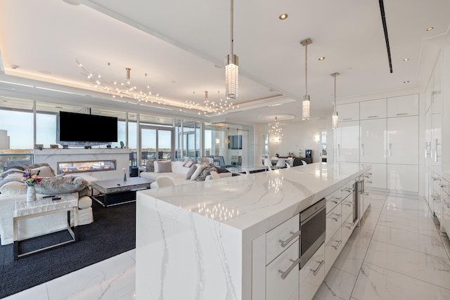 103 S Limestone St Unit 1020, Lexington, KY 40507 - kitchen featuring a raised ceiling, stainless steel microwave, open floor plan, white cabinetry, and modern cabinets