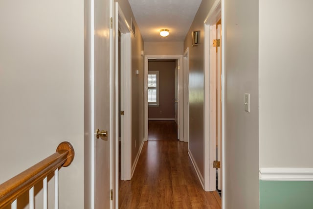 hallway with hardwood / wood-style floors and a textured ceiling