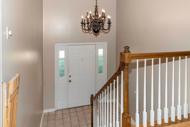 tiled foyer featuring a chandelier