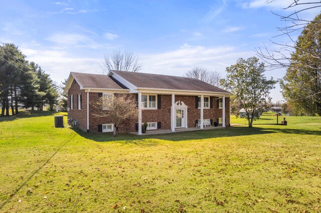 raised ranch featuring a front yard and central AC unit