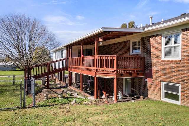 rear view of property featuring a deck and a lawn