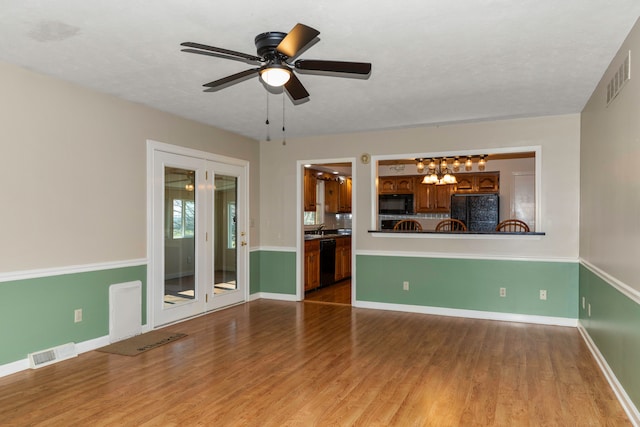 unfurnished living room featuring ceiling fan, hardwood / wood-style floors, and a textured ceiling