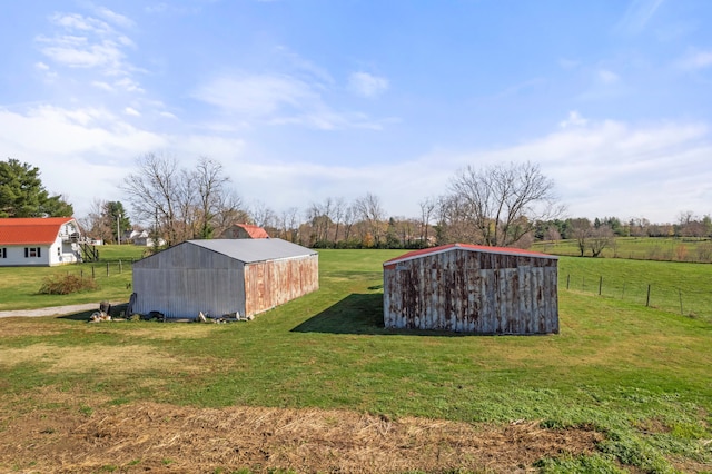 view of outbuilding featuring a rural view and a lawn