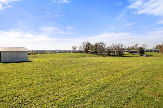 view of yard with a rural view and an outbuilding