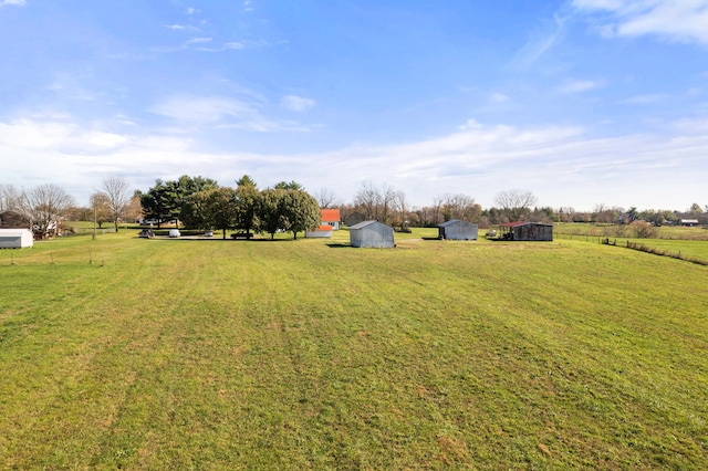 view of yard featuring a rural view and a shed