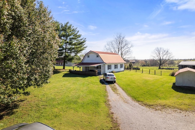 view of front of property featuring a storage unit, a rural view, and a front yard