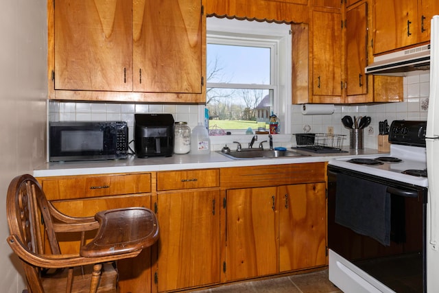 kitchen featuring decorative backsplash, electric range, and sink