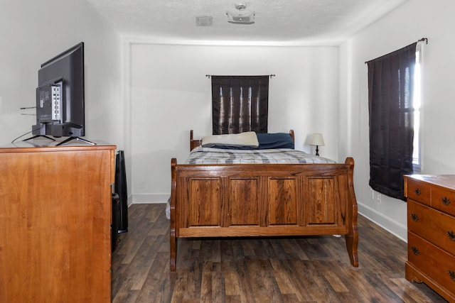 bedroom featuring a textured ceiling and dark hardwood / wood-style floors