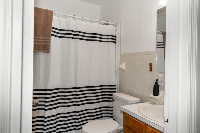 bathroom with walk in shower, vanity, tile walls, and toilet