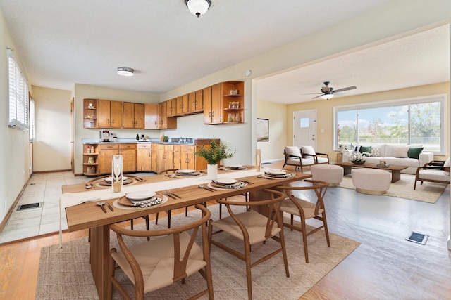 dining area featuring light hardwood / wood-style flooring, ceiling fan, and sink