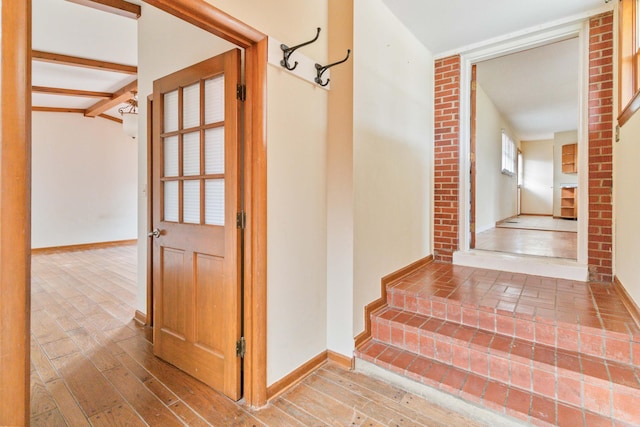 stairs with beamed ceiling and hardwood / wood-style flooring