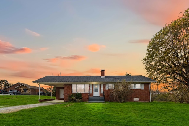 ranch-style house featuring a carport and a lawn