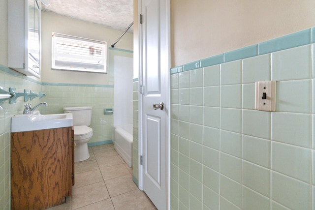 full bathroom with tile patterned floors, tub / shower combination, vanity, a textured ceiling, and toilet