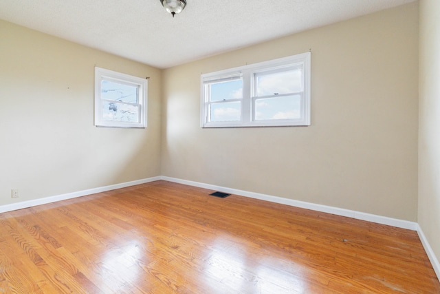 empty room featuring light hardwood / wood-style floors and a textured ceiling