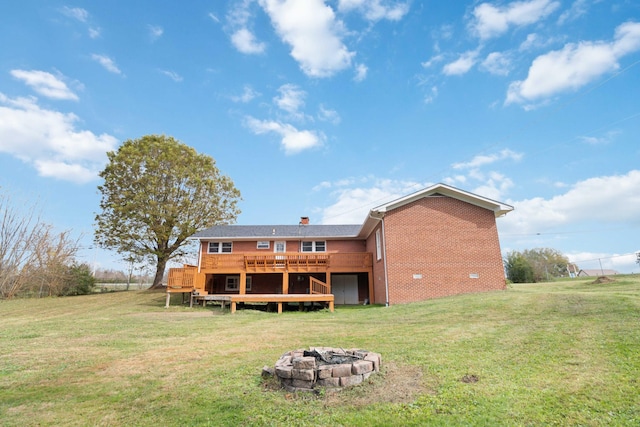 back of house with a yard, an outdoor fire pit, and a wooden deck