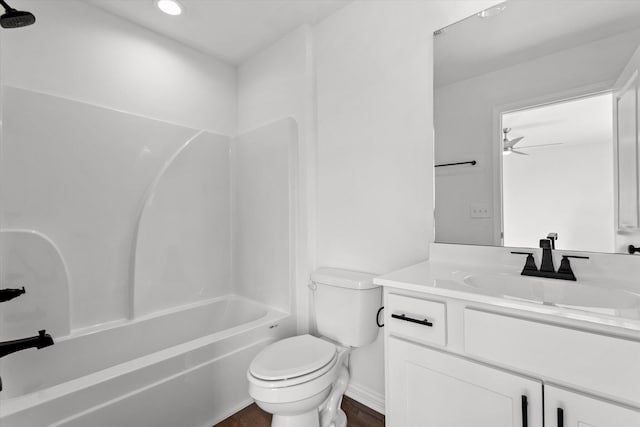 full bathroom featuring hardwood / wood-style flooring, vanity, toilet, ceiling fan, and shower / washtub combination