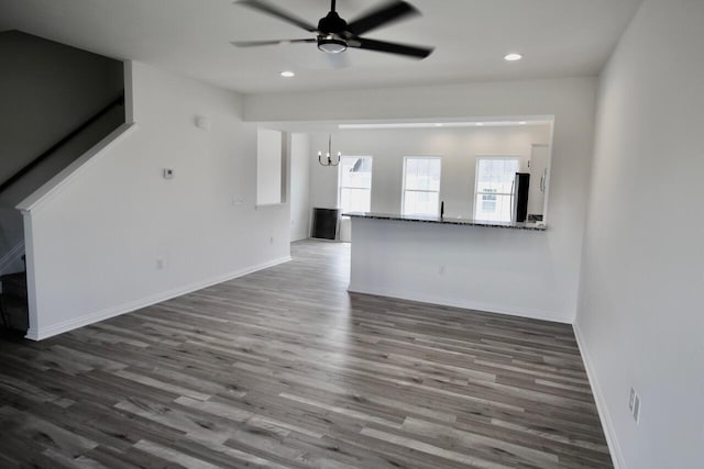 unfurnished living room featuring dark hardwood / wood-style flooring and ceiling fan