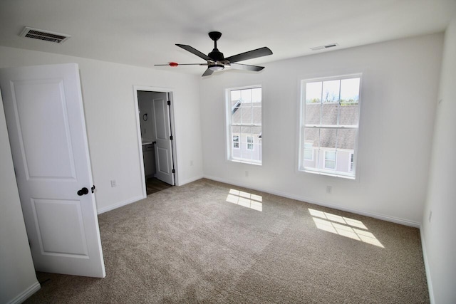 unfurnished bedroom with ceiling fan, ensuite bathroom, and carpet flooring