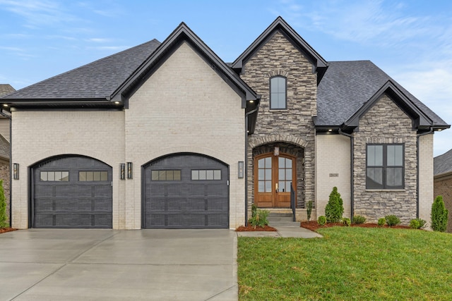 french country inspired facade with a front lawn, a garage, and french doors