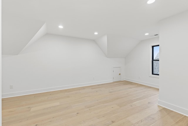 bonus room with light hardwood / wood-style floors and vaulted ceiling