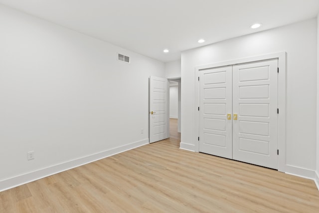 unfurnished bedroom featuring light hardwood / wood-style floors and a closet