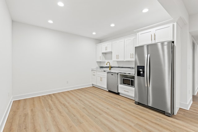 kitchen with sink, light hardwood / wood-style flooring, white cabinets, and appliances with stainless steel finishes