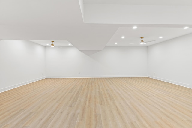 basement with light hardwood / wood-style flooring and ceiling fan