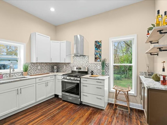 kitchen featuring white cabinets, wall chimney exhaust hood, dark hardwood / wood-style floors, and stainless steel range with gas cooktop