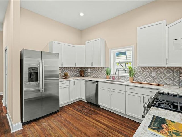 kitchen featuring appliances with stainless steel finishes, white cabinetry, dark wood-type flooring, and sink