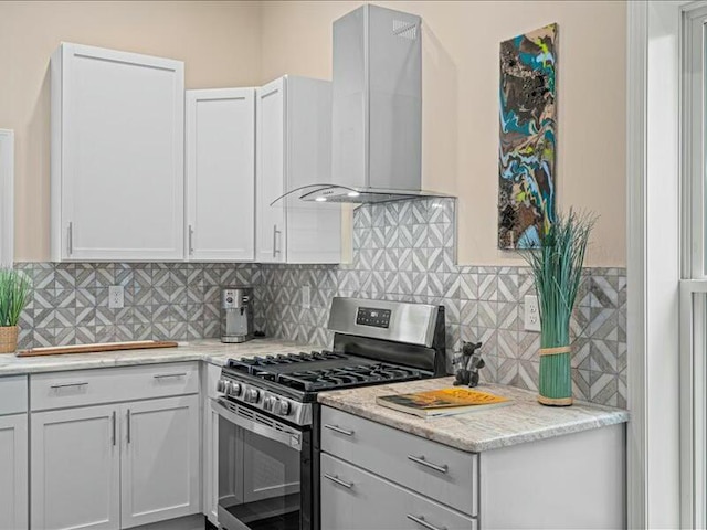 kitchen featuring light stone countertops, wall chimney range hood, backsplash, and gas range