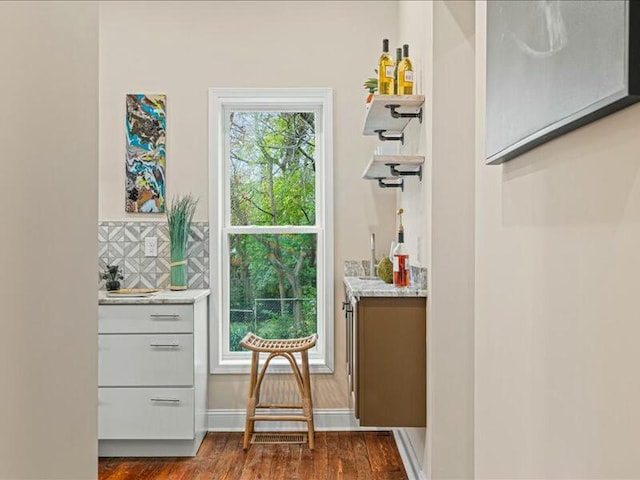 doorway to outside with bar area and dark hardwood / wood-style flooring