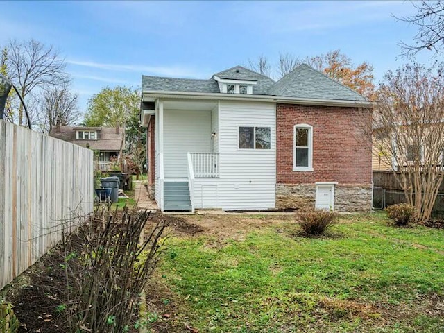 rear view of property featuring a lawn